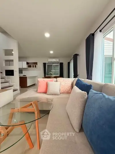 Modern living room with stylish decor and open layout, featuring a cozy sofa and glass coffee table.