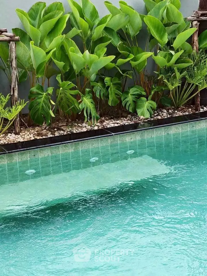 Luxurious outdoor pool with lush greenery for a serene escape