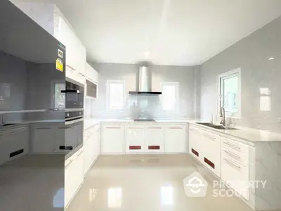 Modern kitchen with sleek white cabinetry and built-in appliances