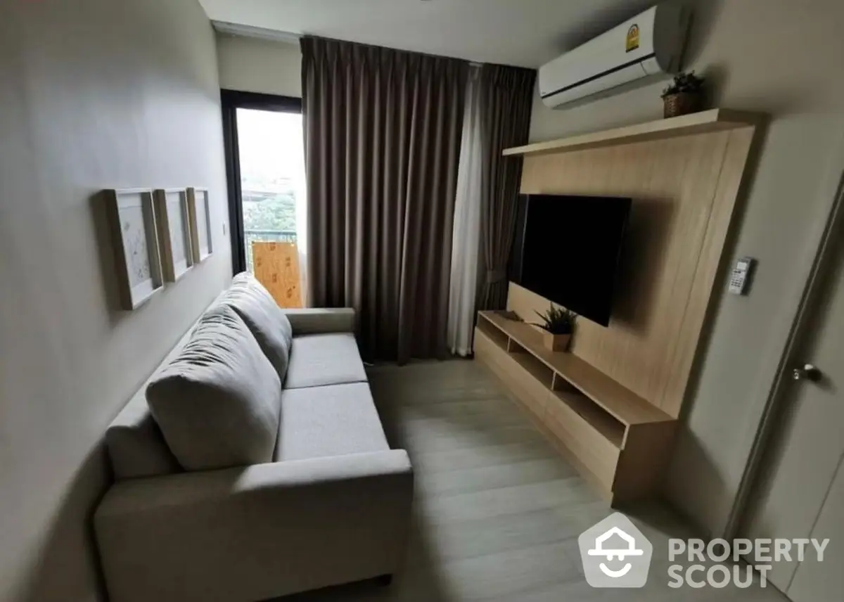 Modern minimalist living room with sleek grey tile flooring, comfortable L-shaped sofa, and built-in wooden entertainment unit, complemented by soft natural lighting.