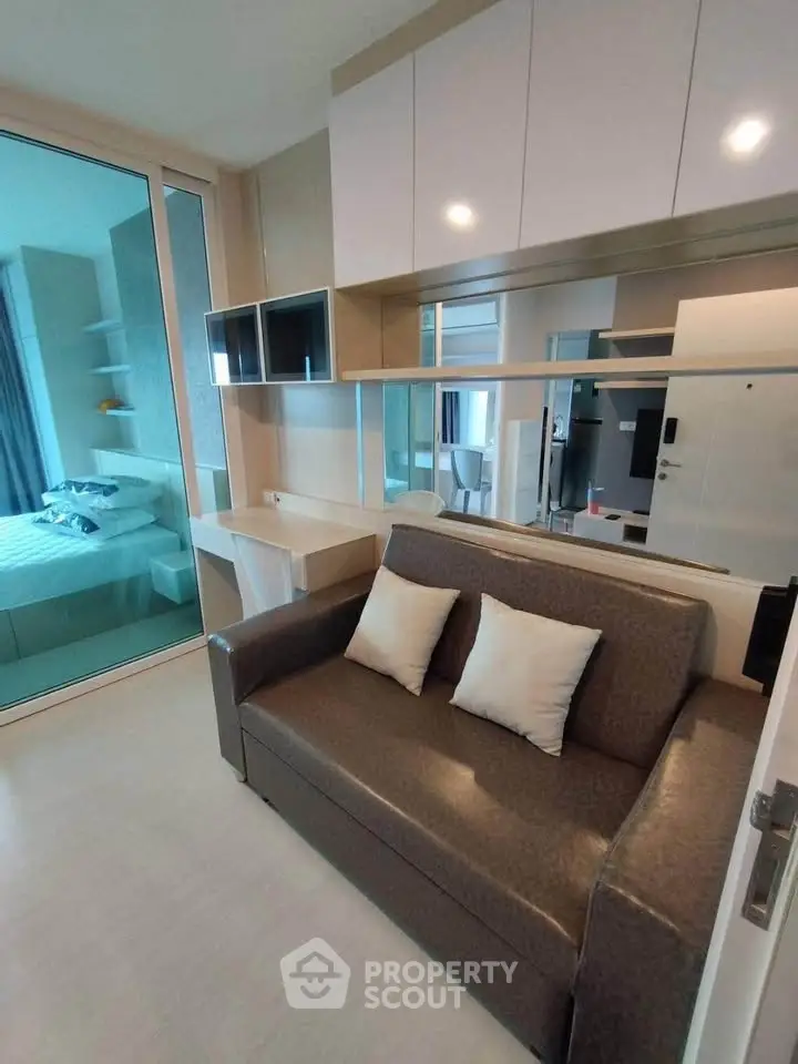 Modern living room with sleek sofa and stylish shelving in a compact apartment setting.