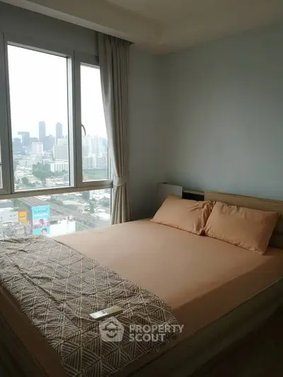 Cozy bedroom with city view, featuring large windows and modern decor.