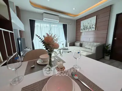 Modern living room with elegant decor and natural light, featuring a cozy sofa and stylish dining area.