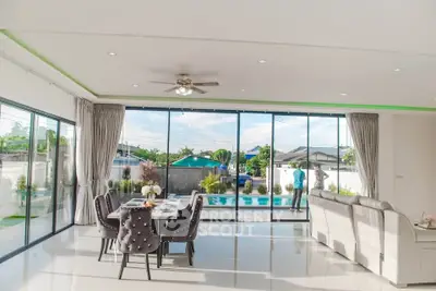 Spacious living room with pool view and elegant dining area