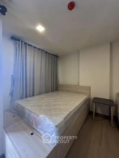 Modern bedroom with sleek wooden flooring and stylish bed setup.