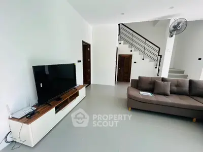 Modern living room with sleek design, featuring a large TV and stylish sofa, perfect for relaxation.