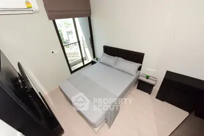 Modern bedroom with sleek design and large window offering natural light