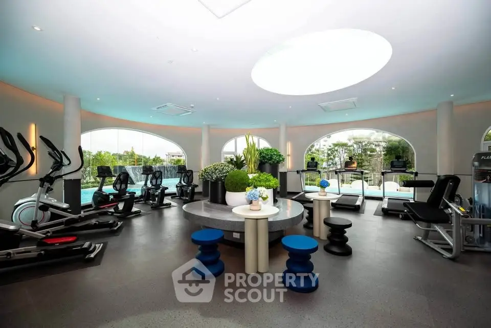 Luxurious gym with modern equipment and scenic views in upscale residential complex.