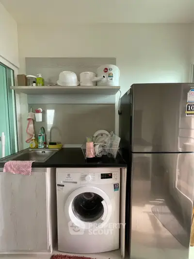 Modern kitchen with washing machine and stainless steel fridge