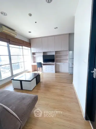 Modern living room with large windows and built-in storage in a high-rise apartment