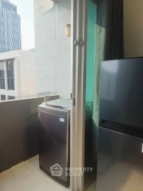 Modern balcony with washing machine and fridge, ideal for urban living.
