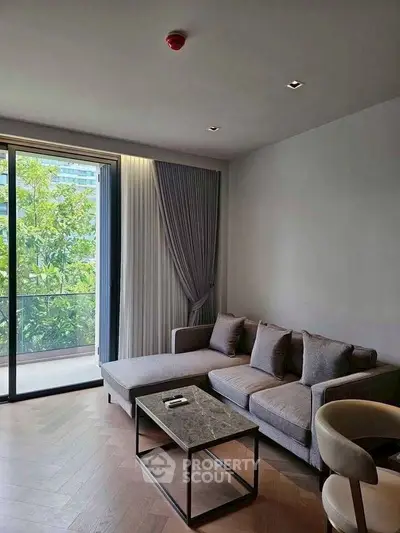 Modern living room with sleek sofa and large window overlooking greenery.