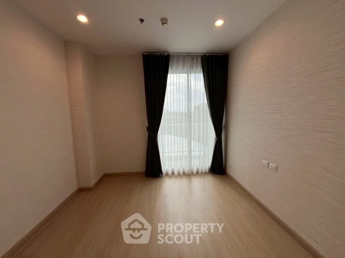 Spacious empty room with large window and elegant curtains