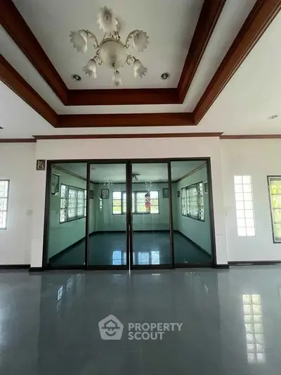 Spacious interior with elegant ceiling design and large glass doors in a modern home.