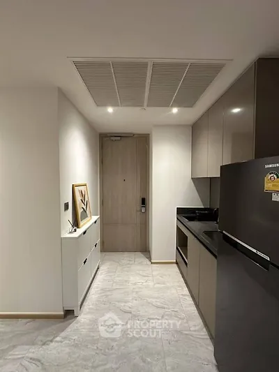 Modern kitchen with sleek cabinetry and stainless steel appliances in a stylish apartment.