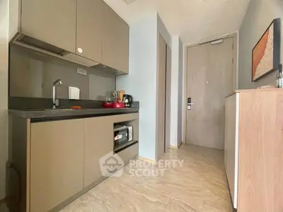Modern compact kitchen with sleek cabinetry and integrated appliances in a stylish apartment.