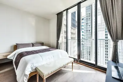 Modern bedroom with floor-to-ceiling windows and city view
