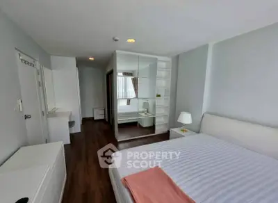 Spacious modern bedroom with mirrored wardrobe and elegant decor