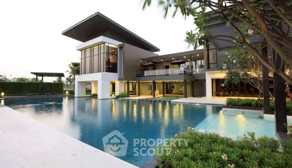 Luxurious modern villa with expansive pool and lush garden, perfect for upscale living and entertaining.