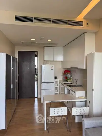 Modern kitchen with sleek white cabinets and appliances in a stylish apartment.