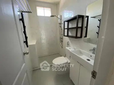 Modern bathroom with sleek fixtures and white cabinetry in a bright, compact space.
