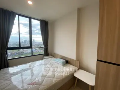 Modern bedroom with large window offering stunning city view, featuring a comfortable bed and sleek furniture.