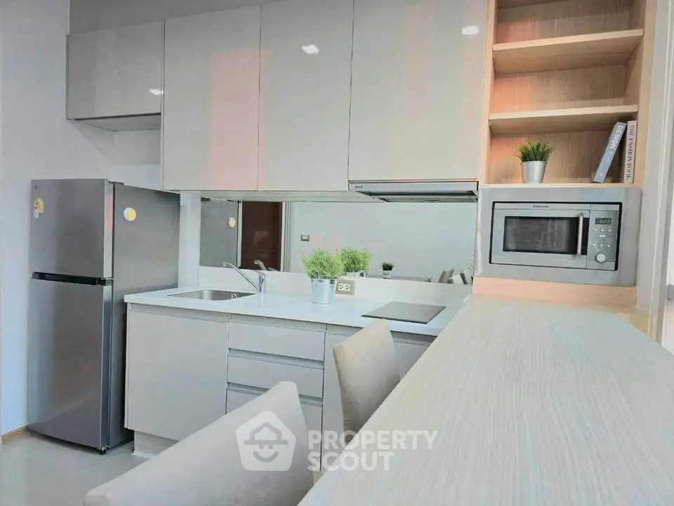Modern kitchen with sleek cabinetry, stainless steel appliances, and cozy dining area.