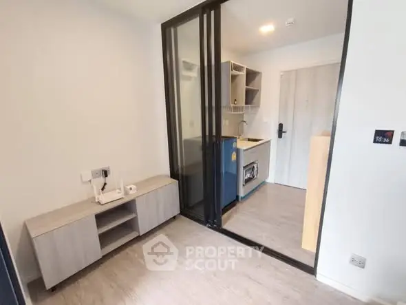 Modern compact kitchen with sliding glass door and sleek cabinetry