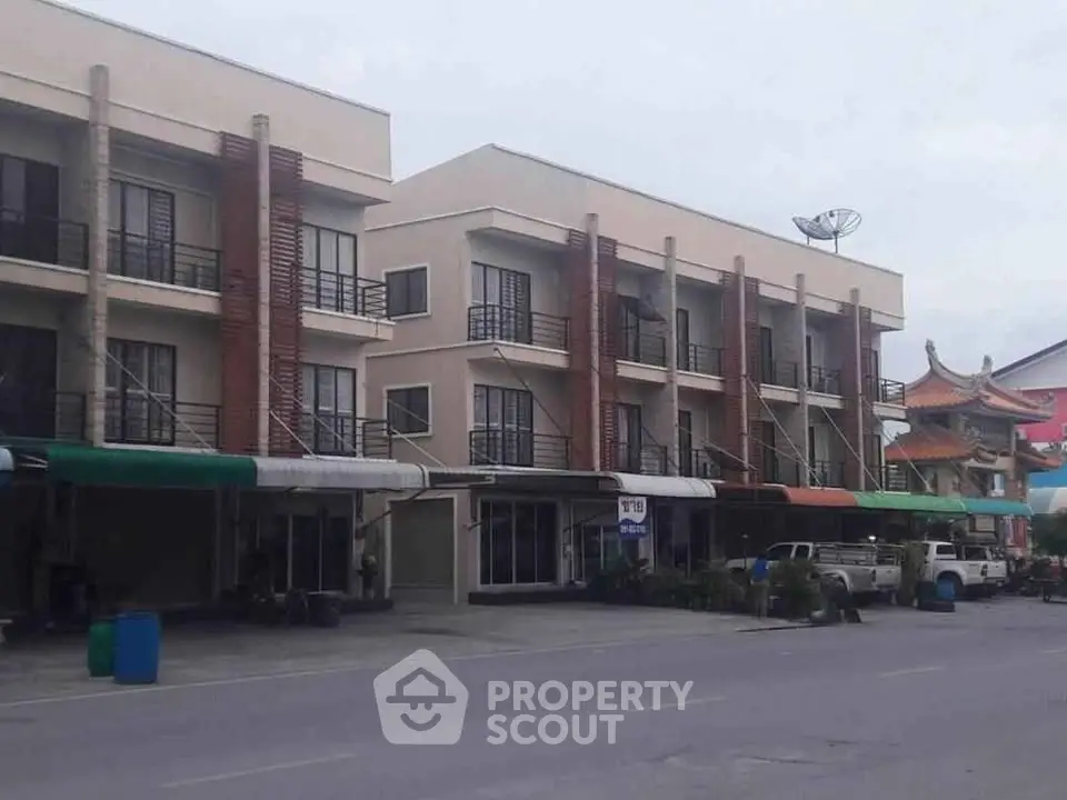 Modern multi-story commercial building with retail spaces and residential units, ideal for investment.