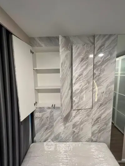 Modern bedroom with sleek marble-patterned storage and cozy ambiance