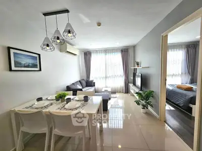 Modern living room with dining area, stylish lighting, and cozy bedroom view.