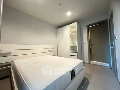 Spacious bedroom with modern white furniture and ample storage space.