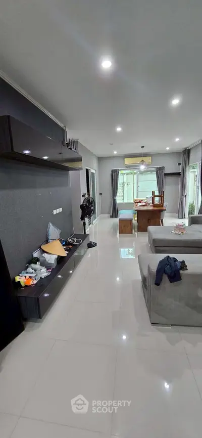 Spacious modern living room with sleek furniture and large windows for natural light.