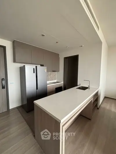 Modern kitchen with sleek design and spacious countertops in a contemporary apartment.