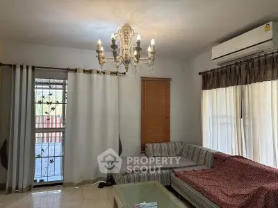 Cozy living room with elegant chandelier and comfortable seating area.