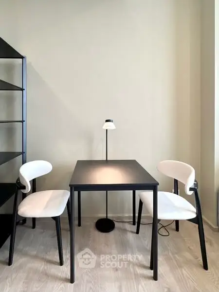 Modern minimalist study area with sleek black table and chairs