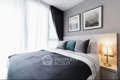 Modern bedroom with stylish decor and large windows offering natural light.