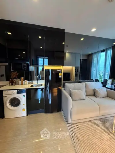 Modern living room with sleek kitchen, featuring washing machine and stylish sofa, ideal for urban living.