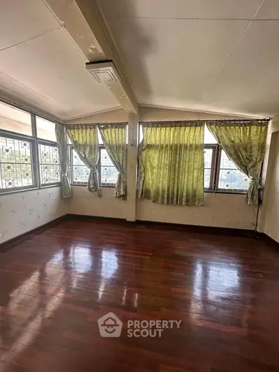 Spacious corner unit with large windows and wooden flooring, ideal for customization.