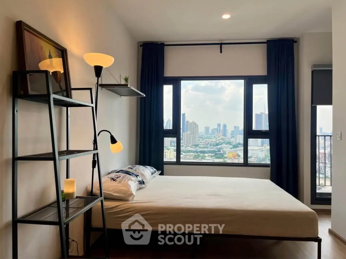 Modern bedroom with city view, featuring stylish decor and large window.