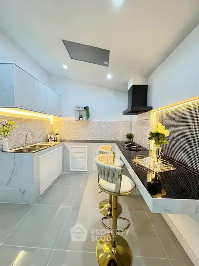 Modern kitchen with sleek design, marble countertops, and stylish bar stools in a bright, contemporary setting.