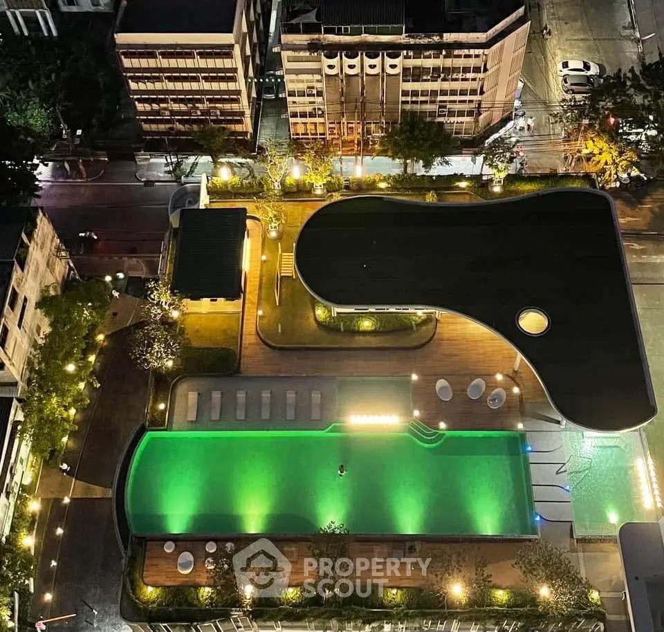 Stunning aerial view of a modern rooftop pool with ambient lighting in an urban setting.