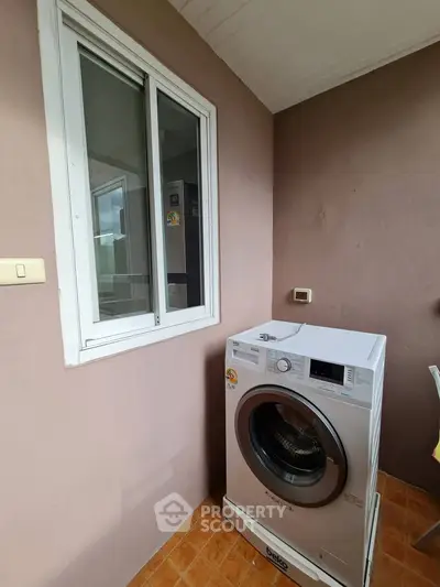 Modern washing machine on tiled balcony with window view
