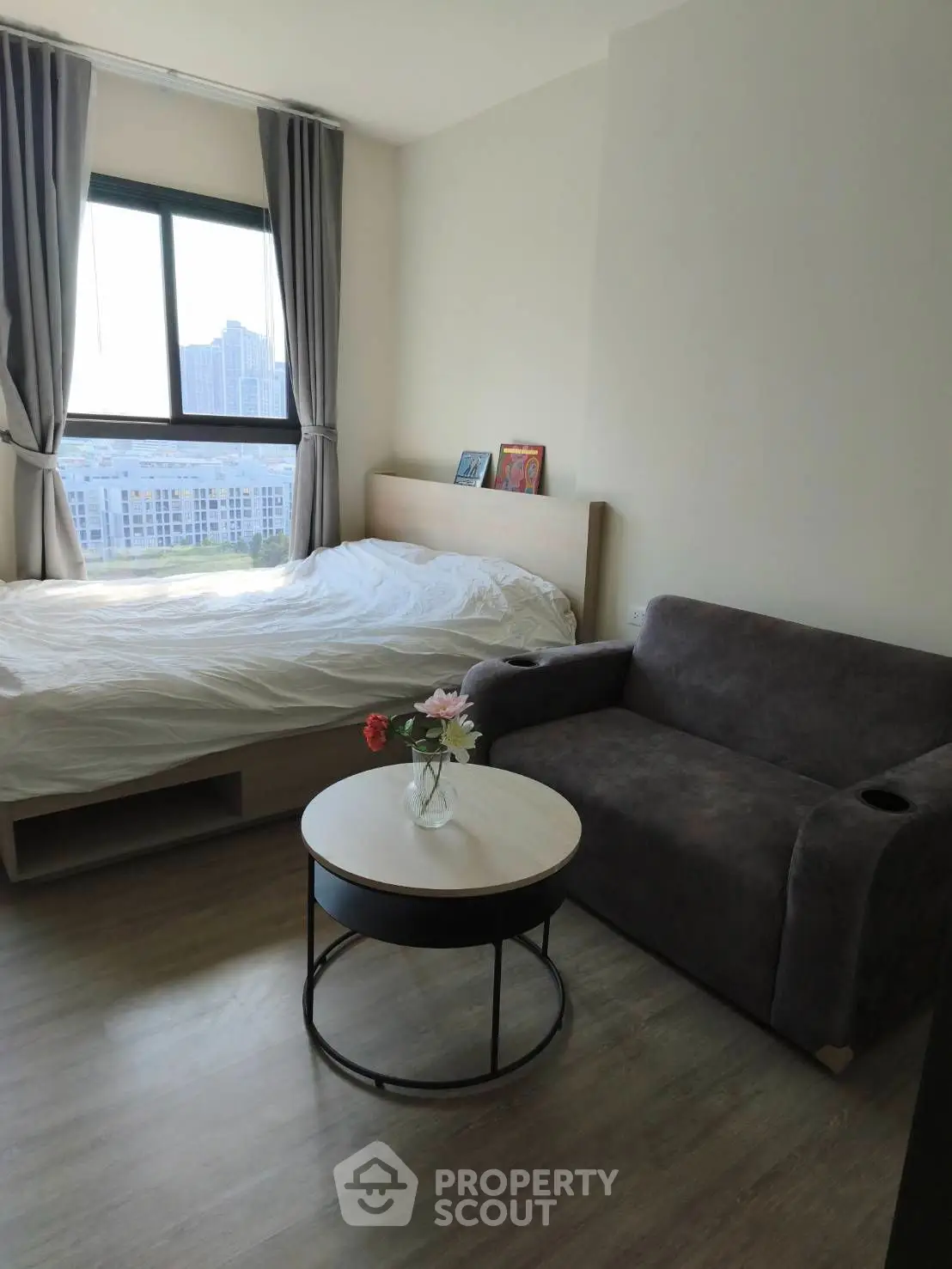 Modern bedroom with large windows and stylish furniture, offering a bright and inviting atmosphere.