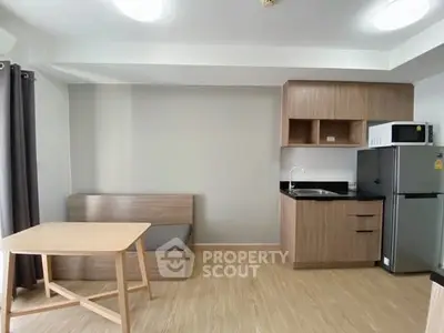 Modern compact kitchen with wooden cabinetry and dining area in apartment