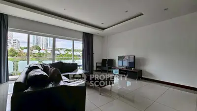 Spacious modern living room with large windows and sleek furniture.