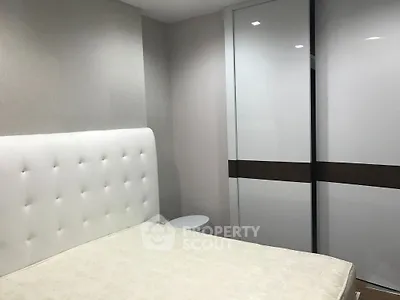 Modern bedroom with sleek white wardrobe and upholstered headboard