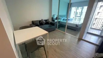 Modern studio apartment with open layout and balcony view, featuring sleek furniture and ample natural light.