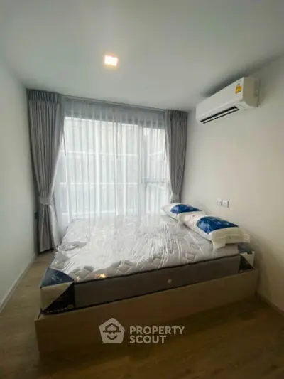 Modern bedroom with large window and air conditioning in a stylish apartment.