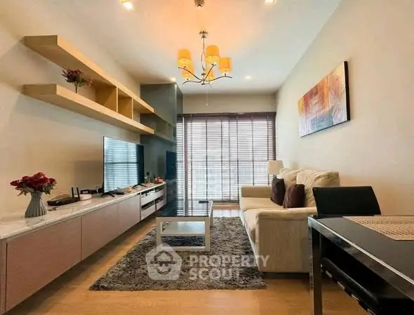 Modern living room with stylish decor and natural light, featuring a cozy sofa and elegant shelving.